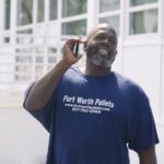 dental implant patient smiling holding phone walking down the street